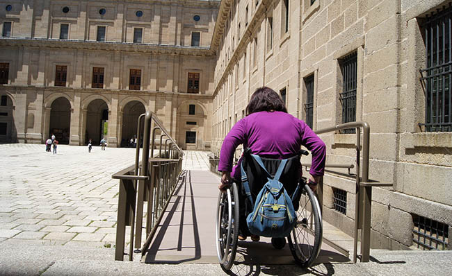 Una persona en silla de ruedas visita San Lorenzo de el Escorial en Madrid