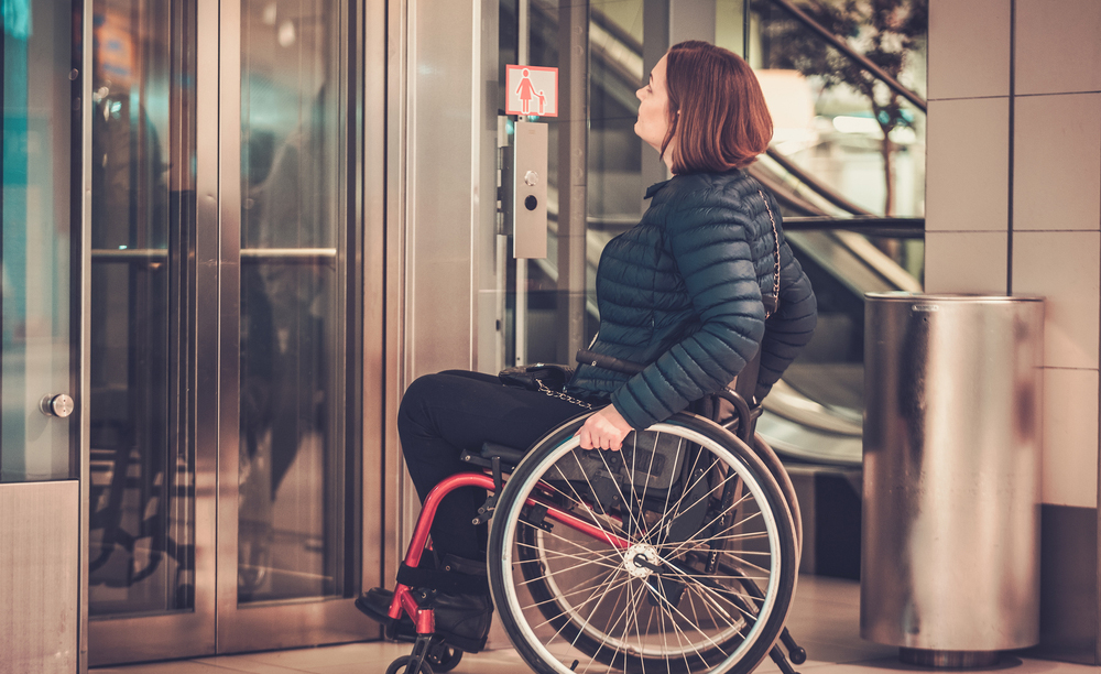 Una mujer en silla de ruedas espera al ascensor