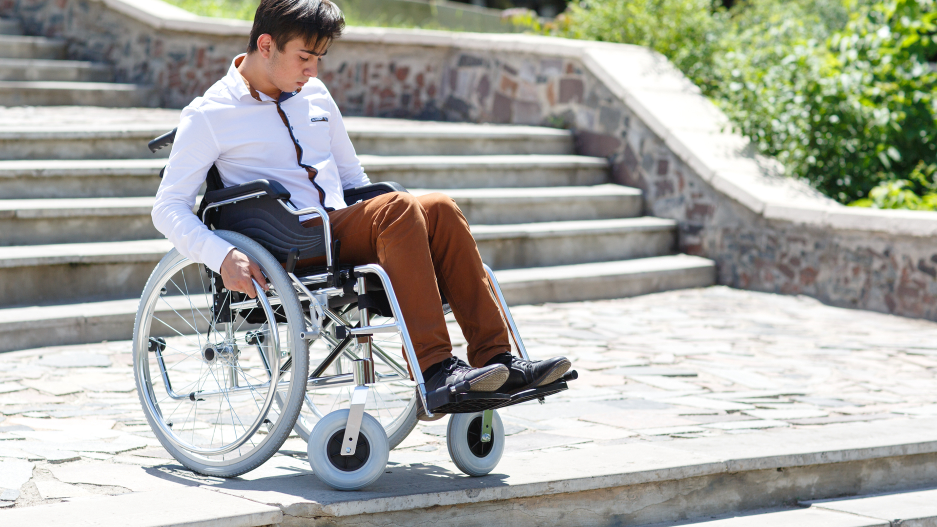 Un joven en silla de ruedas tiene dificultades para bajar unas escaleras