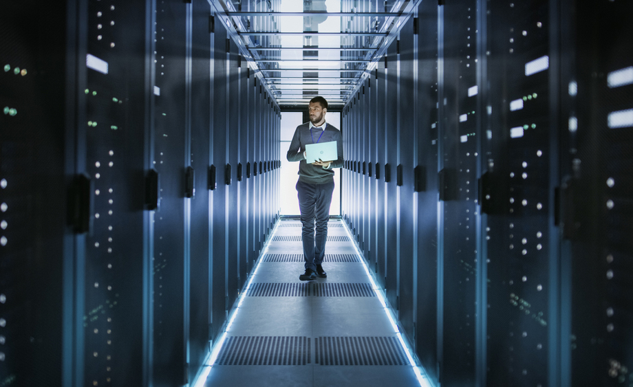 Un hombre anda entre servidores dentro de un centro de datos