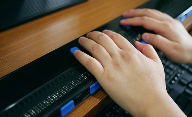 Una persona utiliza una línea braille conectada a un ordenador