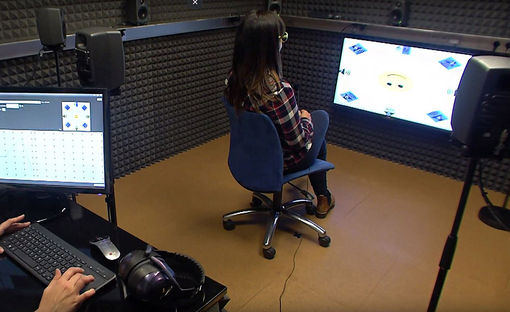 Interior de la cabina de audiometría con un usuario realizando una prueba