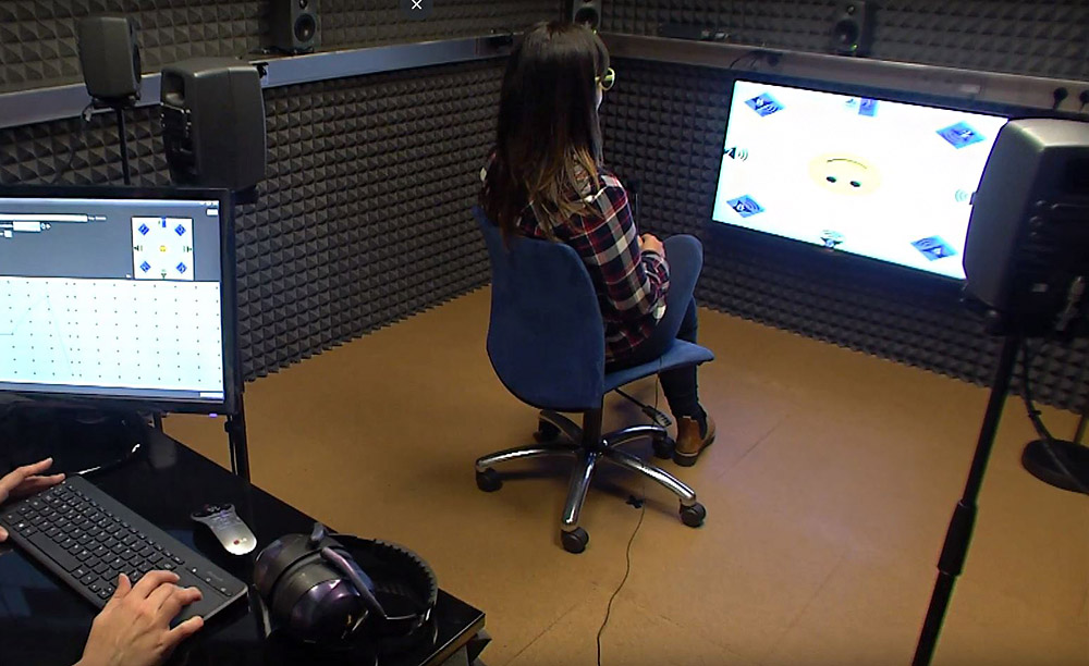 Interior de la cabina de audiometr&iacute;a con un usuario realizando una prueba