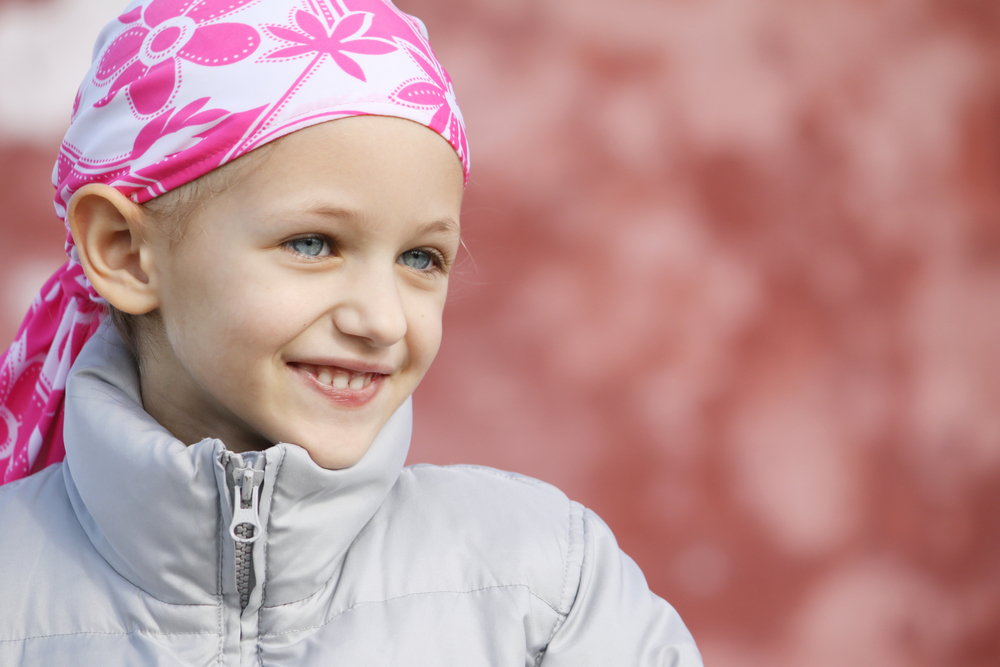 Una niña con la cabeza cubierta por un pañuelo con adornos rosas
