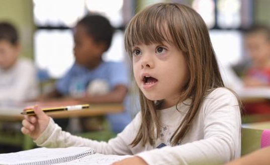 Una niña con discapacidad estudia en un aula escolar