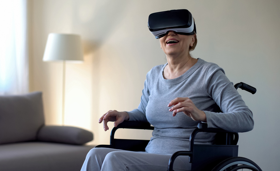 Una mujer mayor en silla de ruedas utiliza unas gafas de realidad virtual