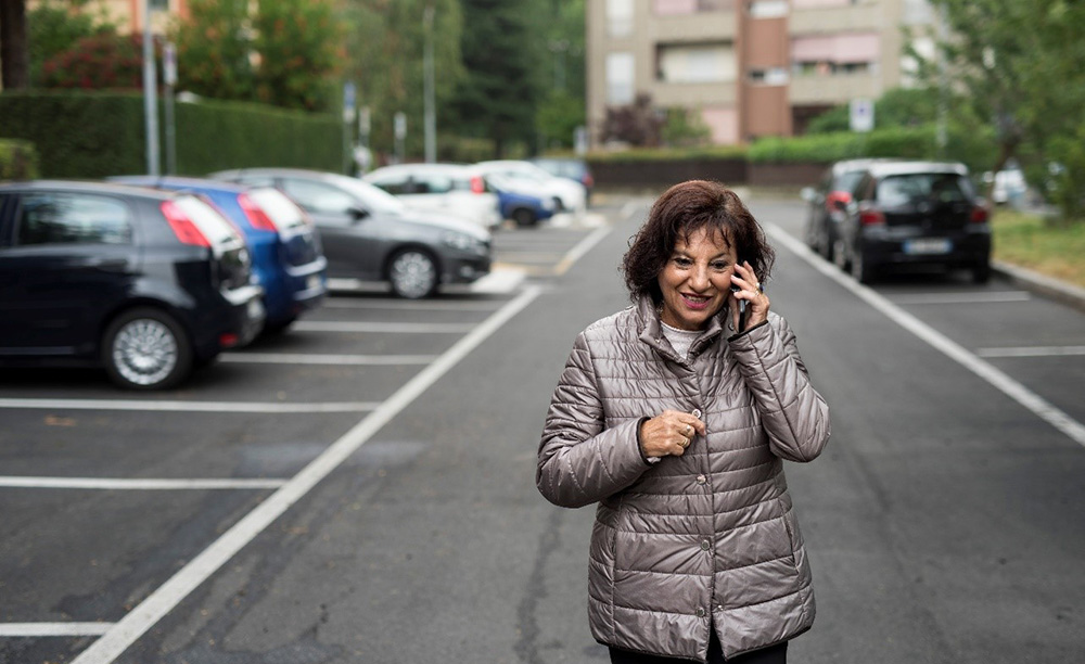 Una mujer mayor habla por el móvil mientras anda por la calle