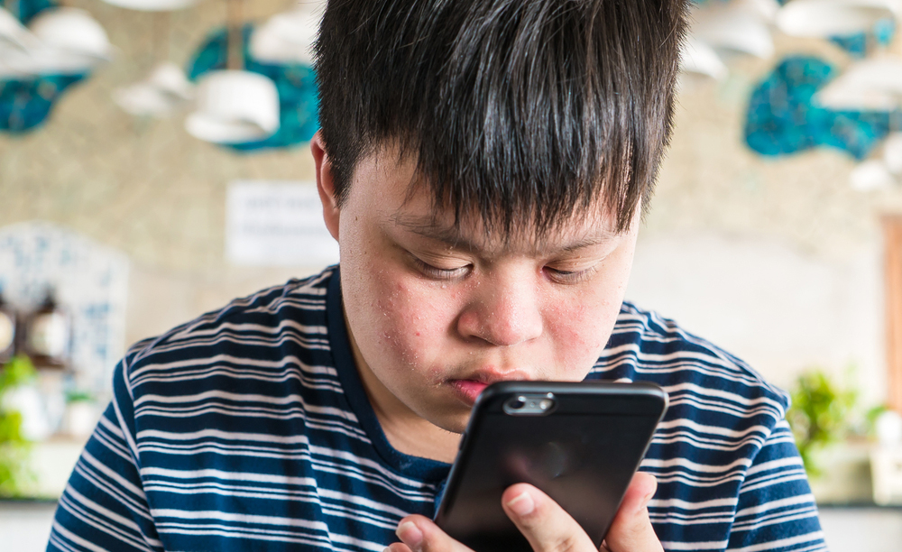 Un niño con síndrome de Down utiliza un smartphone