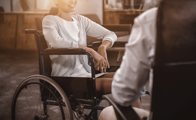 Una mujer en silla de ruedas habla con otra persona