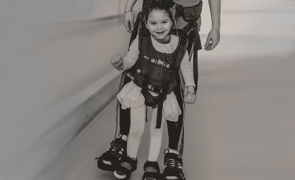 Imagen de la campaña de apoyo a la investigación del daño cerebral que muestra a una niña aprendiendo a andar
