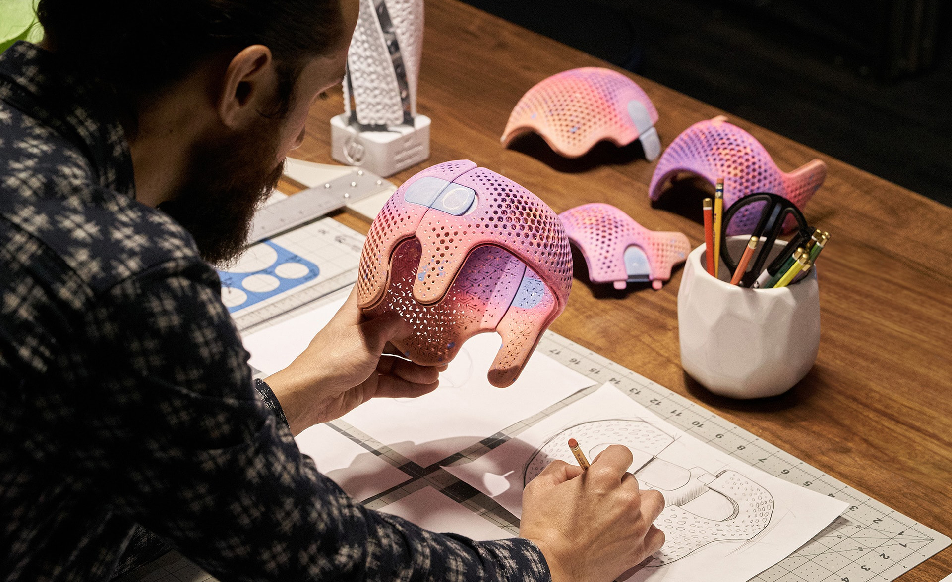 Un ingeniero revisa unos cascos protectores impresos con las nuevas HP Jet Fusion 300/500