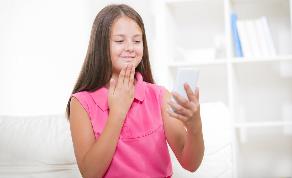 Una joven utiliza la lengua de signos frente a su teléfono móvil