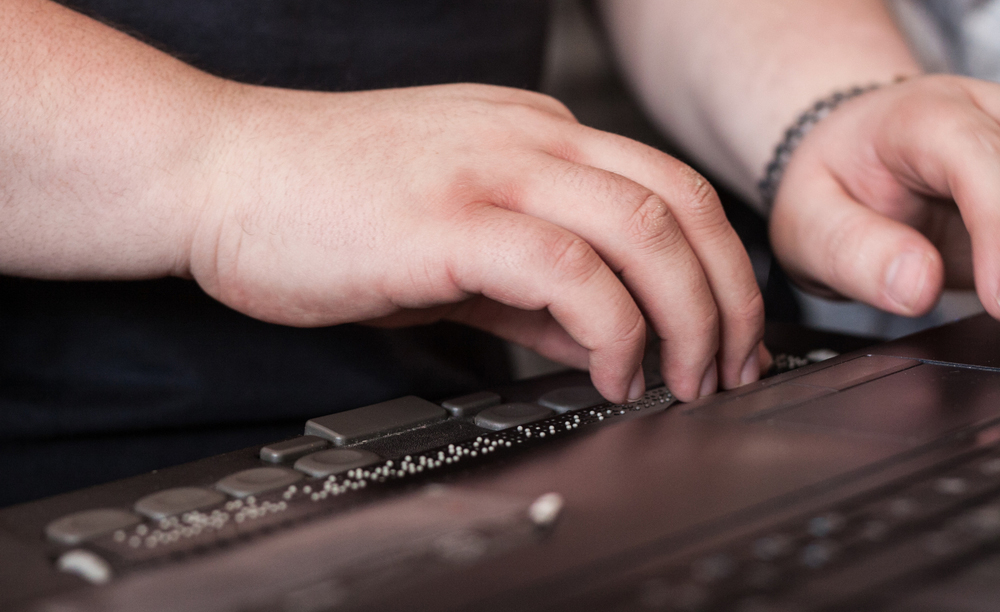 Una persona utiliza una línea braille en su ordenador