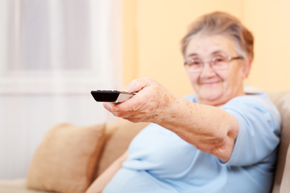 Una mujer mayor utiliza el mando de la televisión