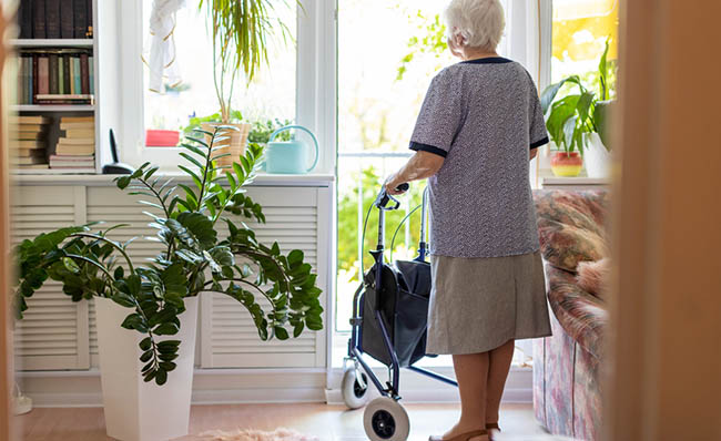 Una persona mayor utiliza su andador en el interior de su vivienda
