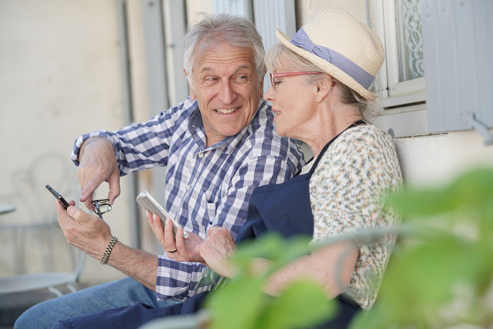 Una pareja de personas mayores utiliza un smartphone