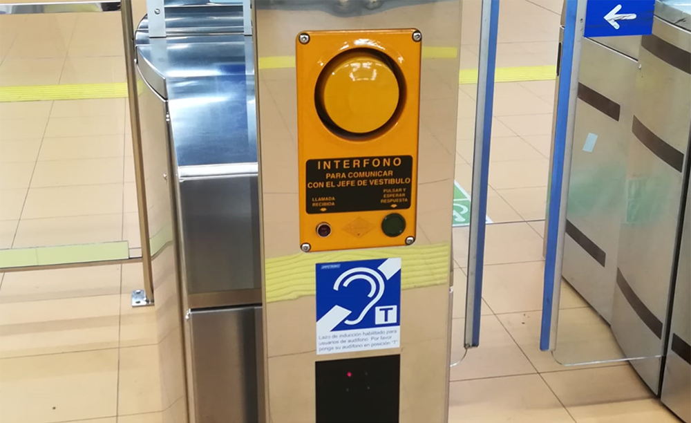 Señal de bucle de inducción junto a un interfono en una de las estaciones del Metro de Madrid