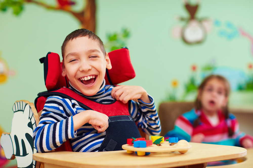 Un niño con discapacidad ríe en una sala de juegos