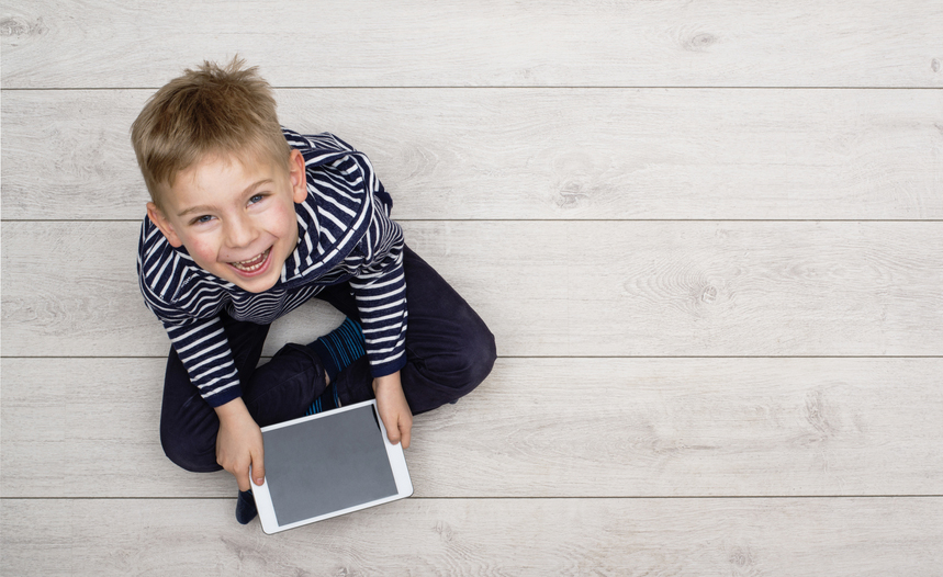 Un ni&ntilde;o sentado en el suelo utiliza una tableta