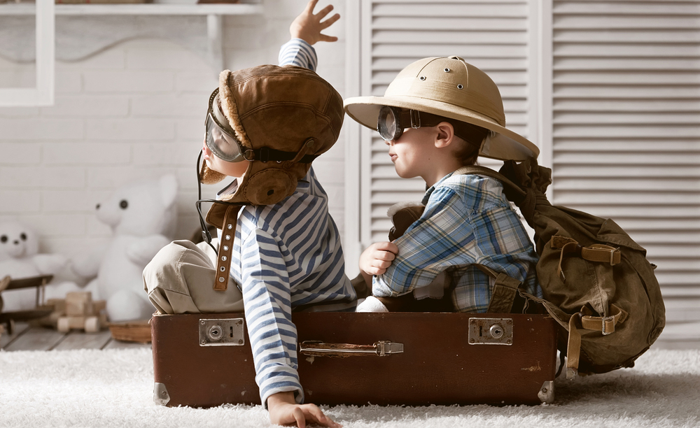 Dos niños juegan a ser pilotos dentro de una maleta