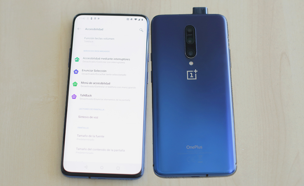 Imagen de dos One Plus 7 Pro mostrando las opciones de accesibilidad y la parte trasera con la c&aacute;mara frontal desplegada