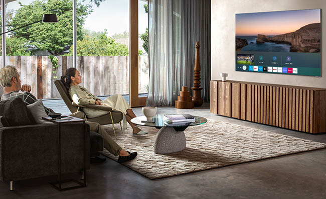 Una pareja de personas mayores ve la televisión en un televisor inteligente de Samsung