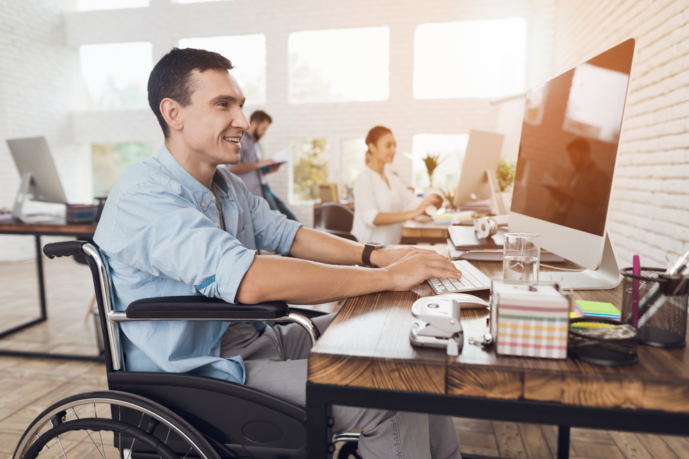 Un joven en silla de ruedas trabaja en una oficina
