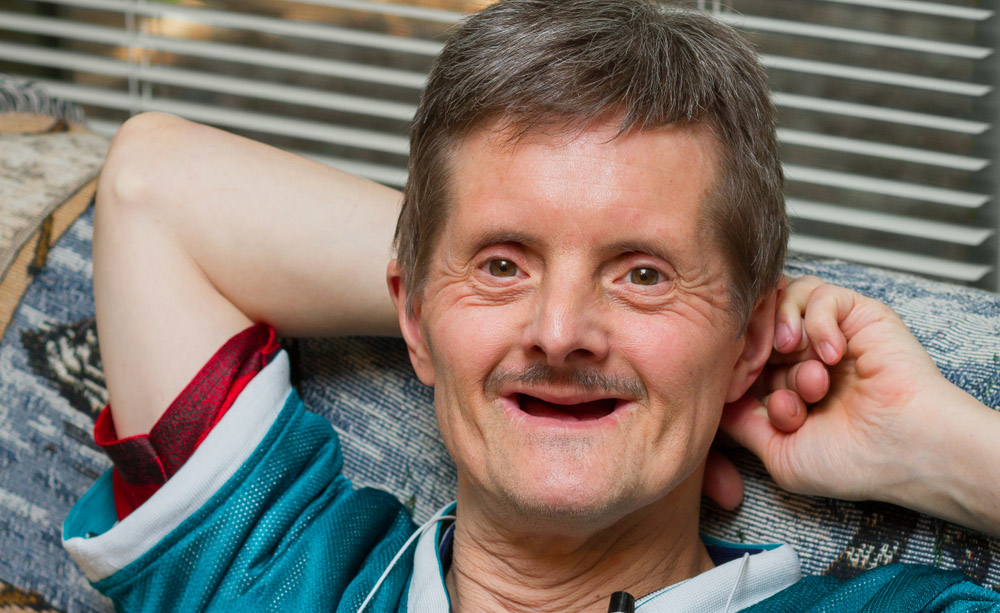 Fotografía de un hombre con síndrome de Down sonriente