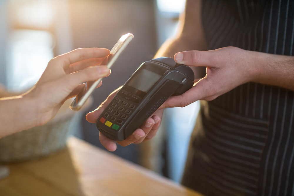 Una persona paga en un establecimiento utilizando su smartphone
