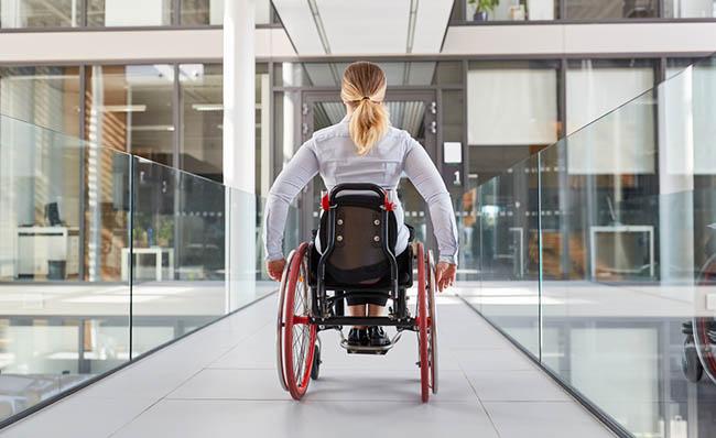 Una mujer en silla de ruedas se desplaza en el interior de un edificio
