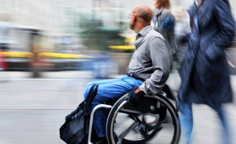 Una persona en silla de ruedas se mueve por las calles de una ciudad