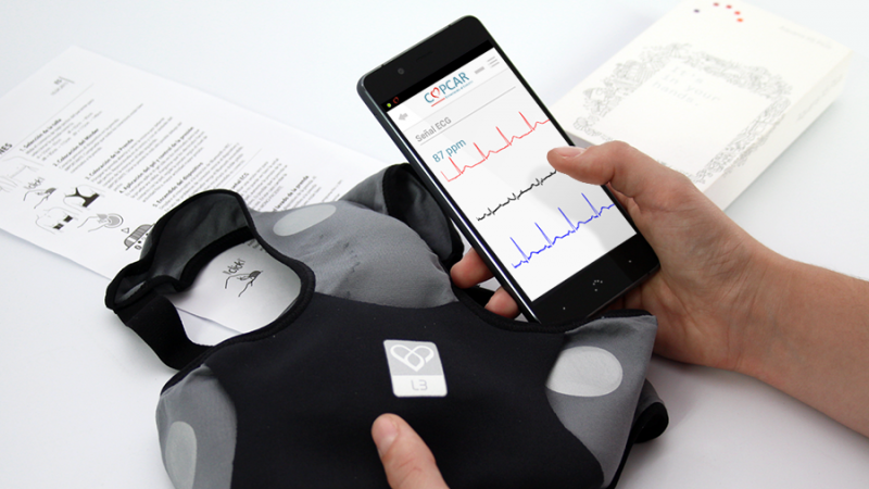 Imagen de una personas con la aplicación de Copcar y una prenda textil con sensores en la mano
