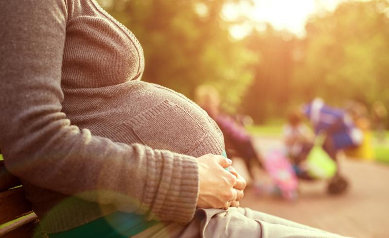 Una mujer embarazada sentada en un parque
