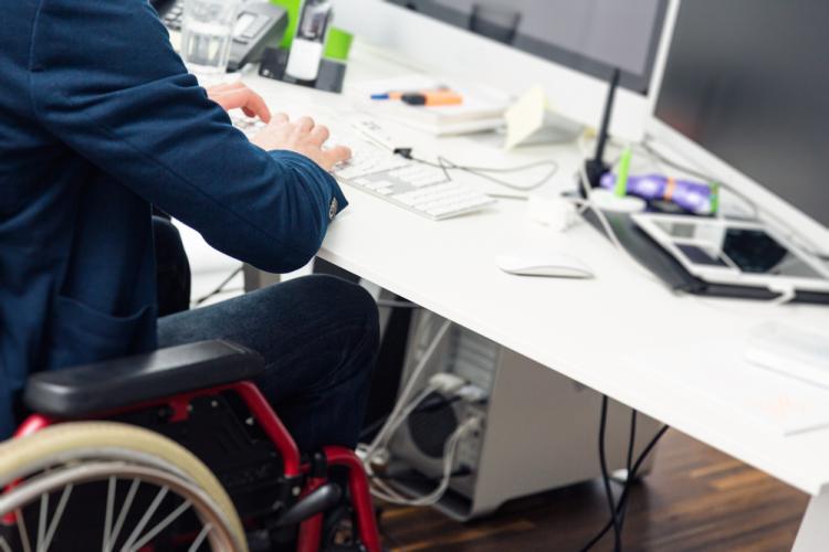 Una persona en silla de ruedas trabaja en una oficina