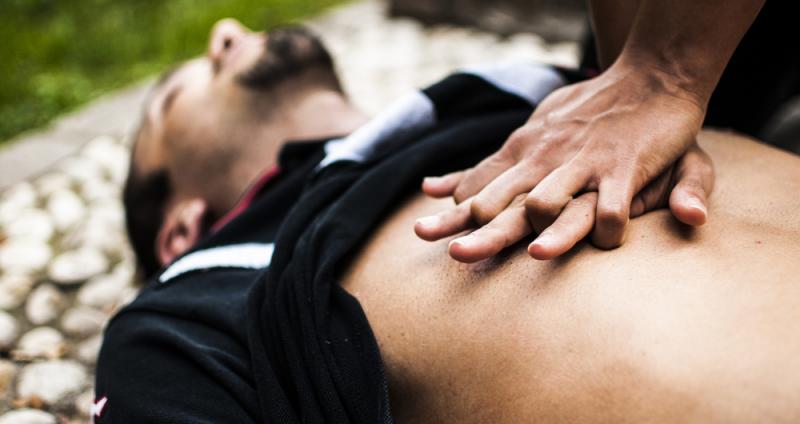 Una persona realiza ejercicios de reanimación cardio-pulmonar sobre un hombre tumbado