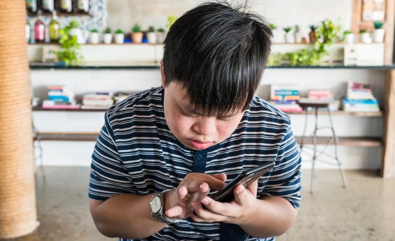 Un joven con síndrome de Down utiliza un teléfono móvil