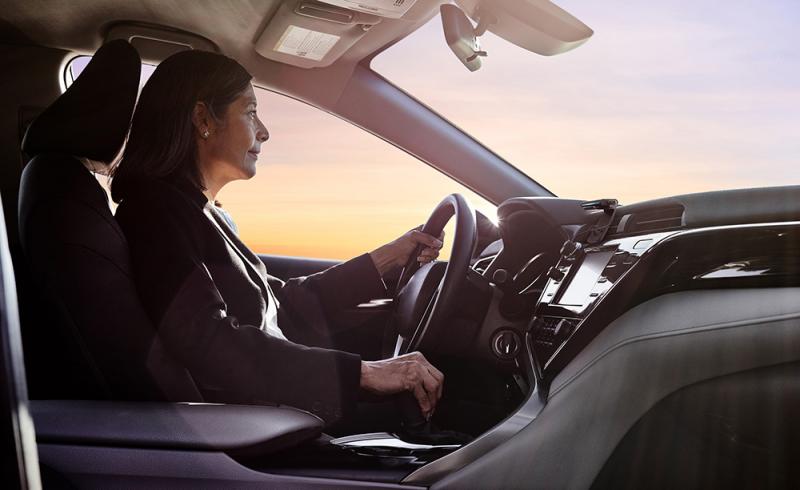 Una mujer conduce su coche con un Echo Auto conectado