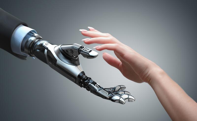 Imagen en la que una mano de un robot se acerca a una mano de una persona