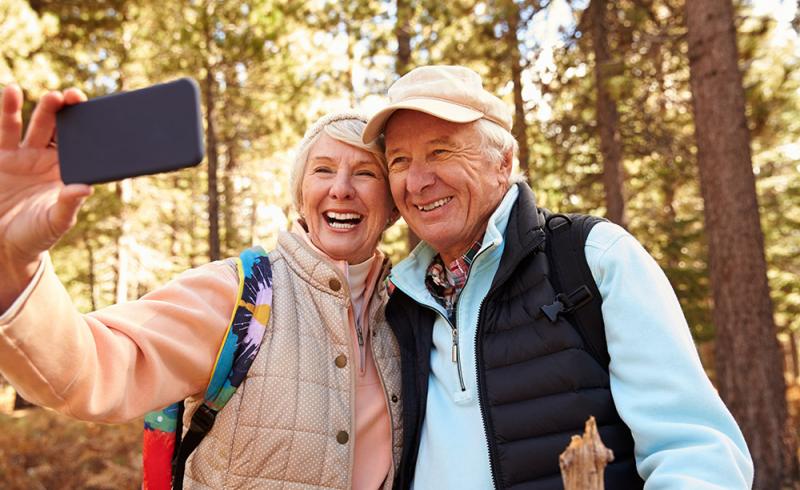 Una mujer y un hombre mayores se hacen una fotografía en un bosque