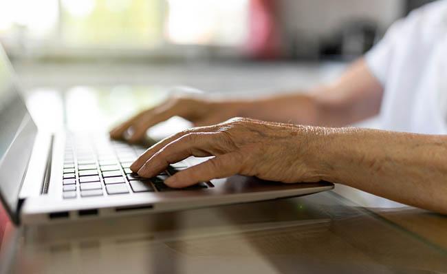 Una persona mayor utiliza un ordenador portátil