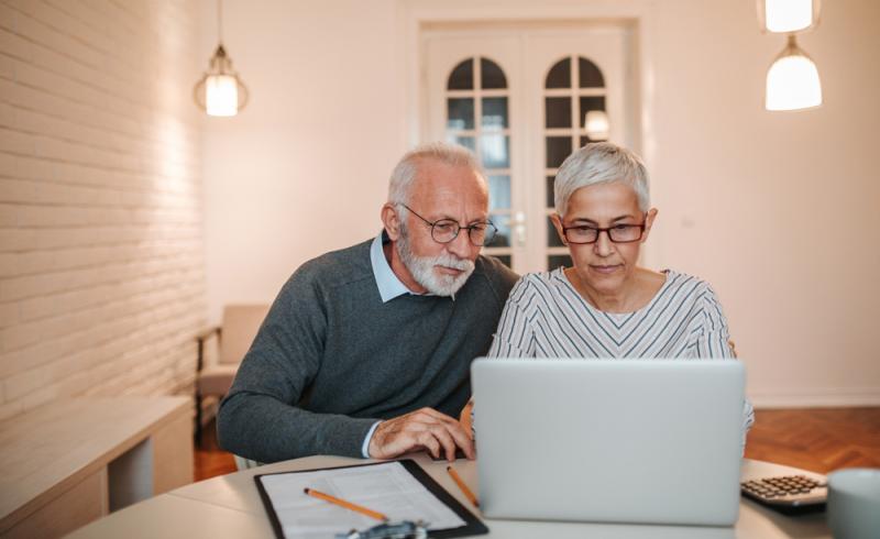 Una pareja de personas mayores gestiona su banca online desde casa