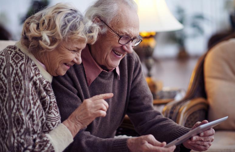 Dos personas mayores miran una tableta