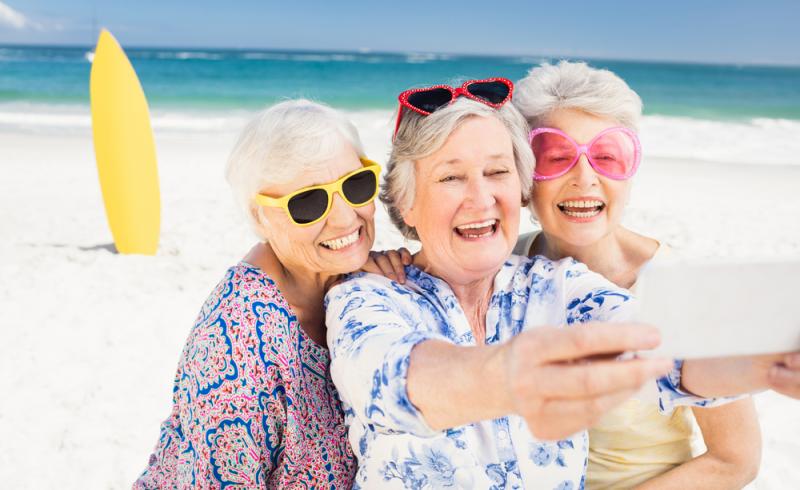 Tres mujeres mayores se hacen un 'selfie' en una playa