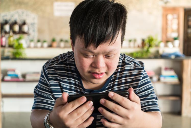 Un joven con sindrome de Down utiliza un teléfono móvil