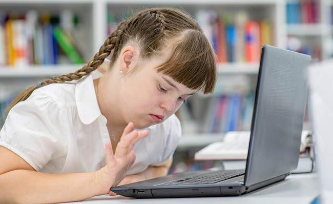 Una niña con síndrome de Down utiliza un ordenador