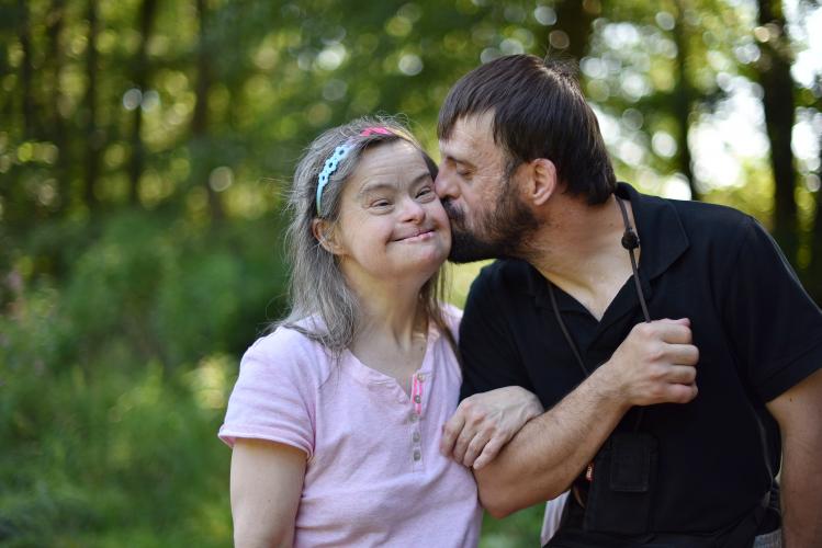 Una pareja de personas con discapacidad se besa en el campo