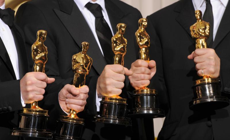 Varias personas con un premio Oscar en la mano
