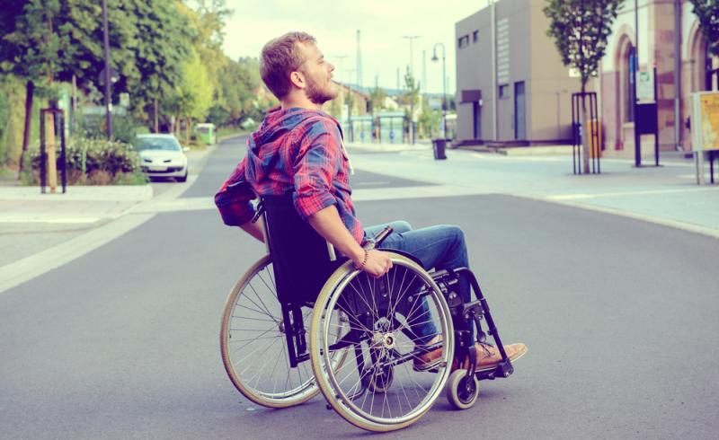 Un joven en silla de ruedas en mitad de la calle