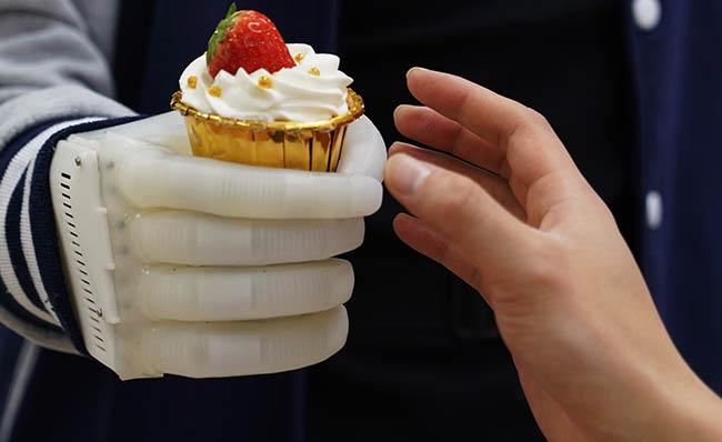 Imagen de la prótesis de mano hinchable cogiendo un pastel