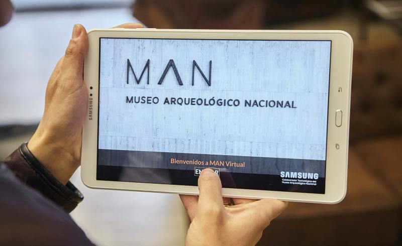Una mano sujeta una tableta en la que se está utilizando la aplicación del MAN
